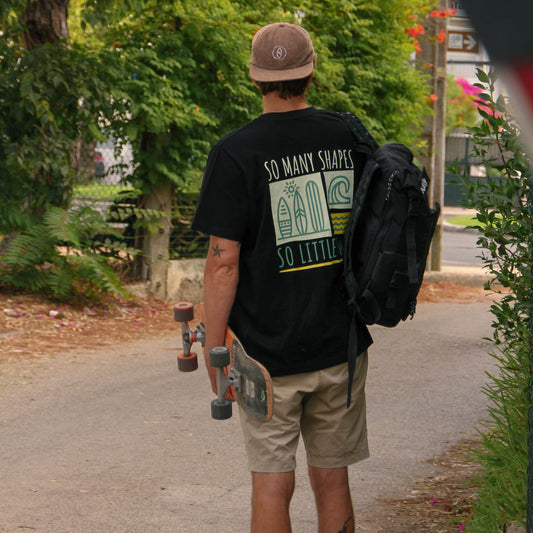 Person walking with a skateboard on a path, with a stop sign in the foreground.