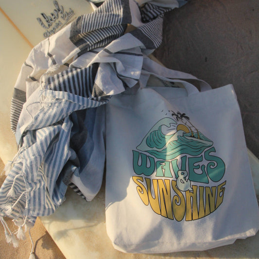 Tote bag with 'Waves and Sunshine' design on a sandy background
