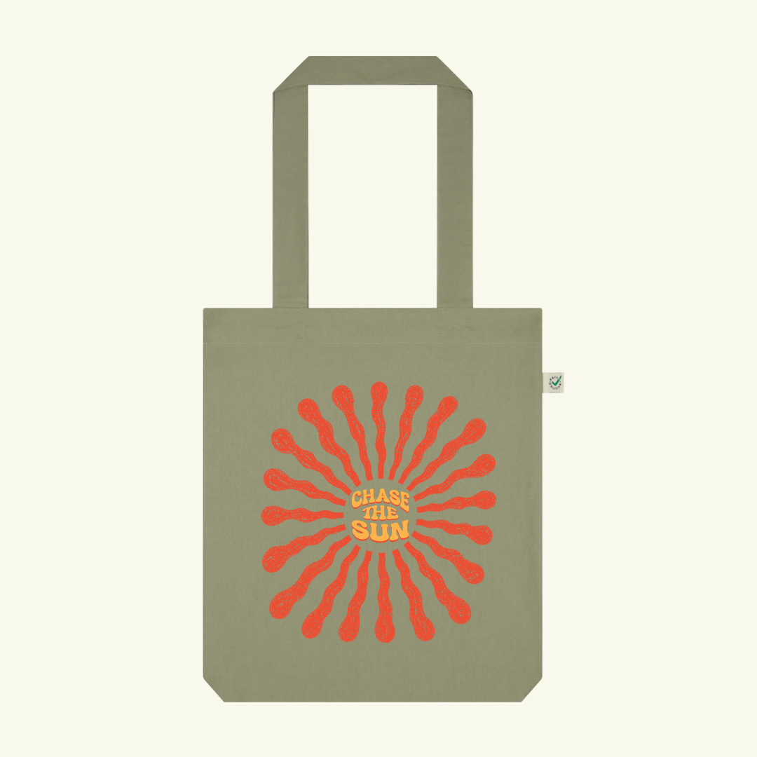 Green tote bag with red sun design and 'Chase the Sun' text on a white background
