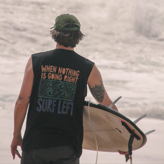 Person holding a surfboard with a motivational message on a beach