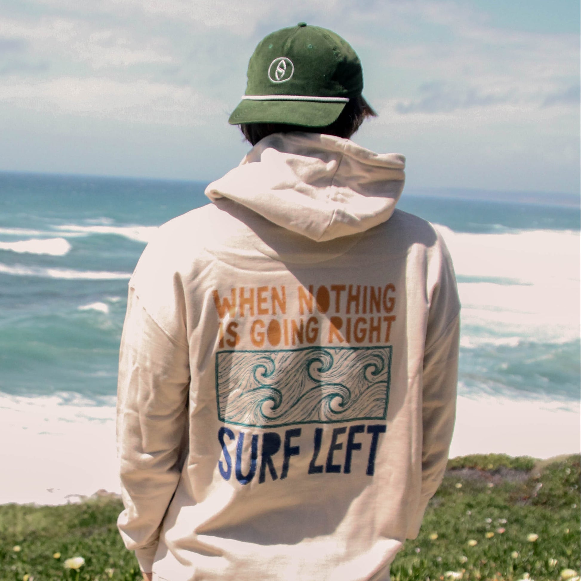 Person wearing a hoodie with a motivational quote by the ocean