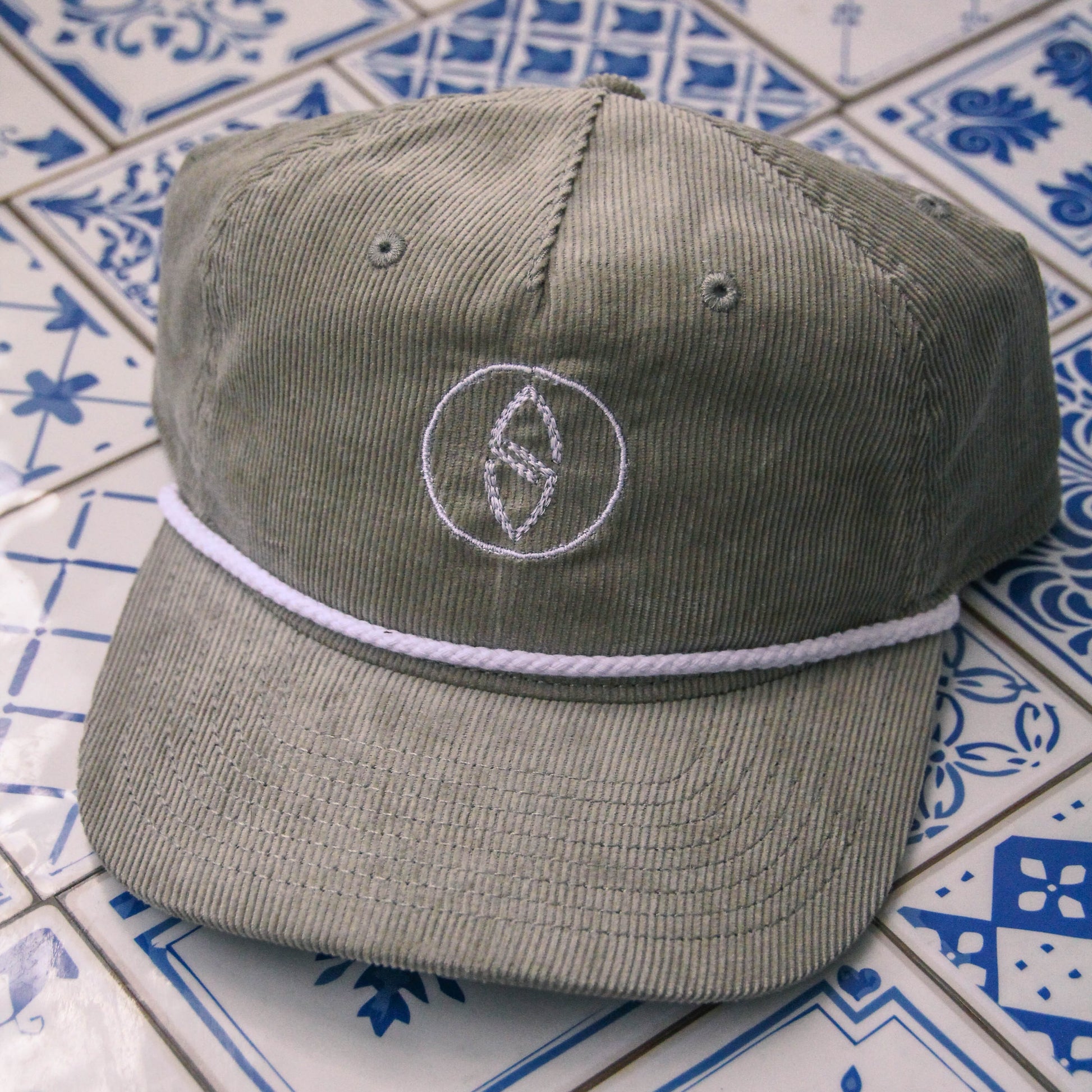 Gray cap with a logo on a tiled surface
